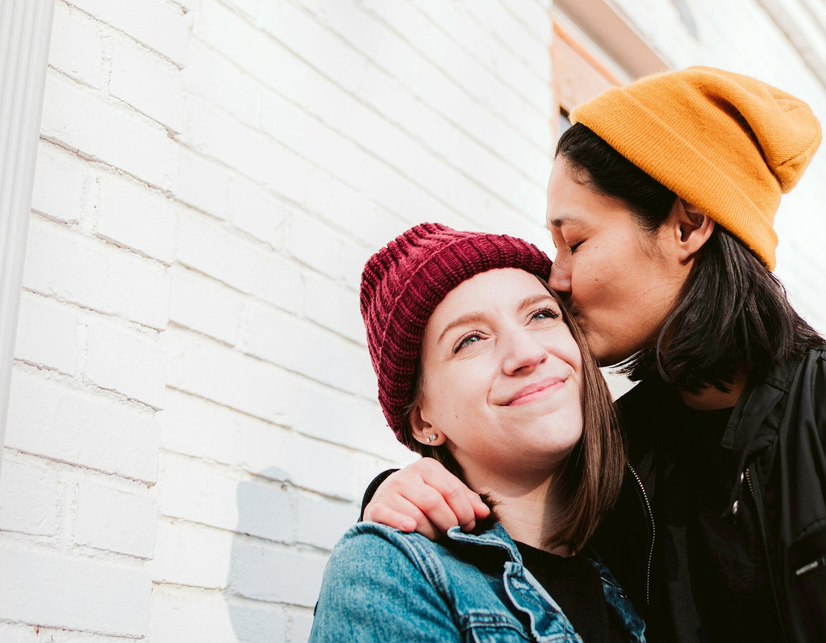 A queer couple hugs.